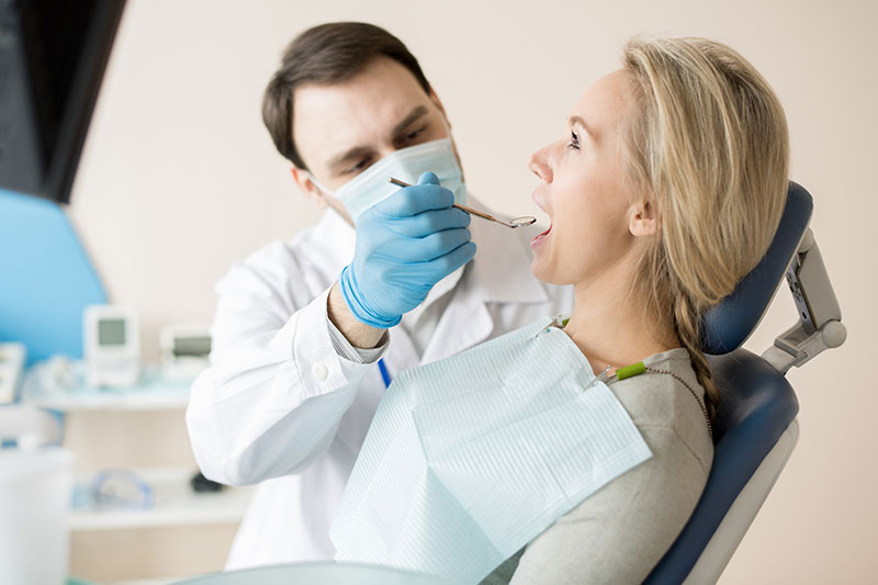 doctor-watching-teeth-of-woman-in-cabinet-72J8RAX-(1)