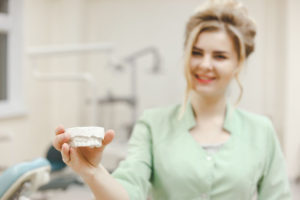 Woman Doctor Orthodontist Shows A Plaster Cast Of Pafln