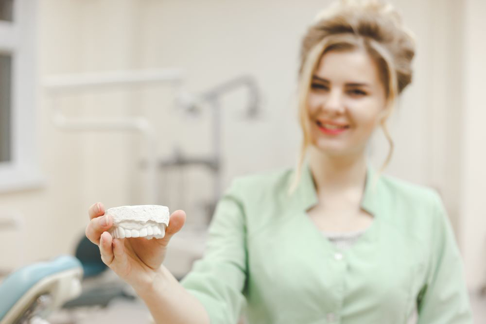 Woman Doctor Orthodontist Shows A Plaster Cast Of Pafln